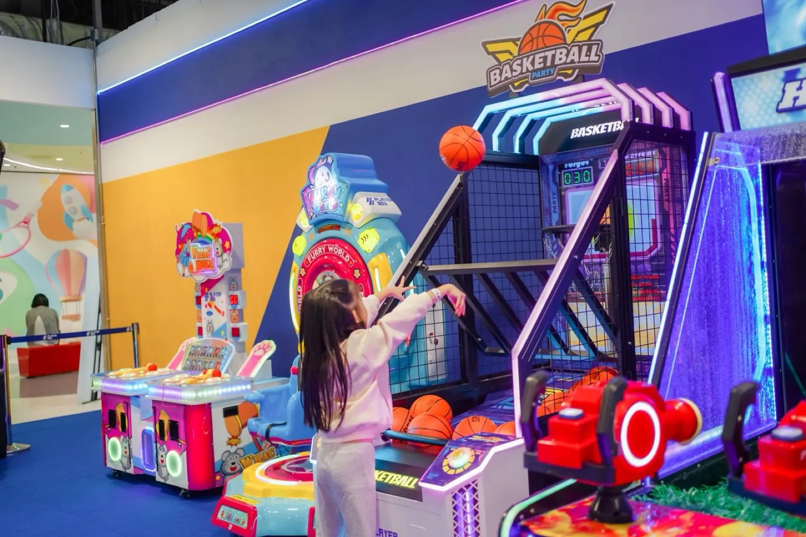 A child shooting hoops on the Basketball Party arcade machine at Central Rama 3
