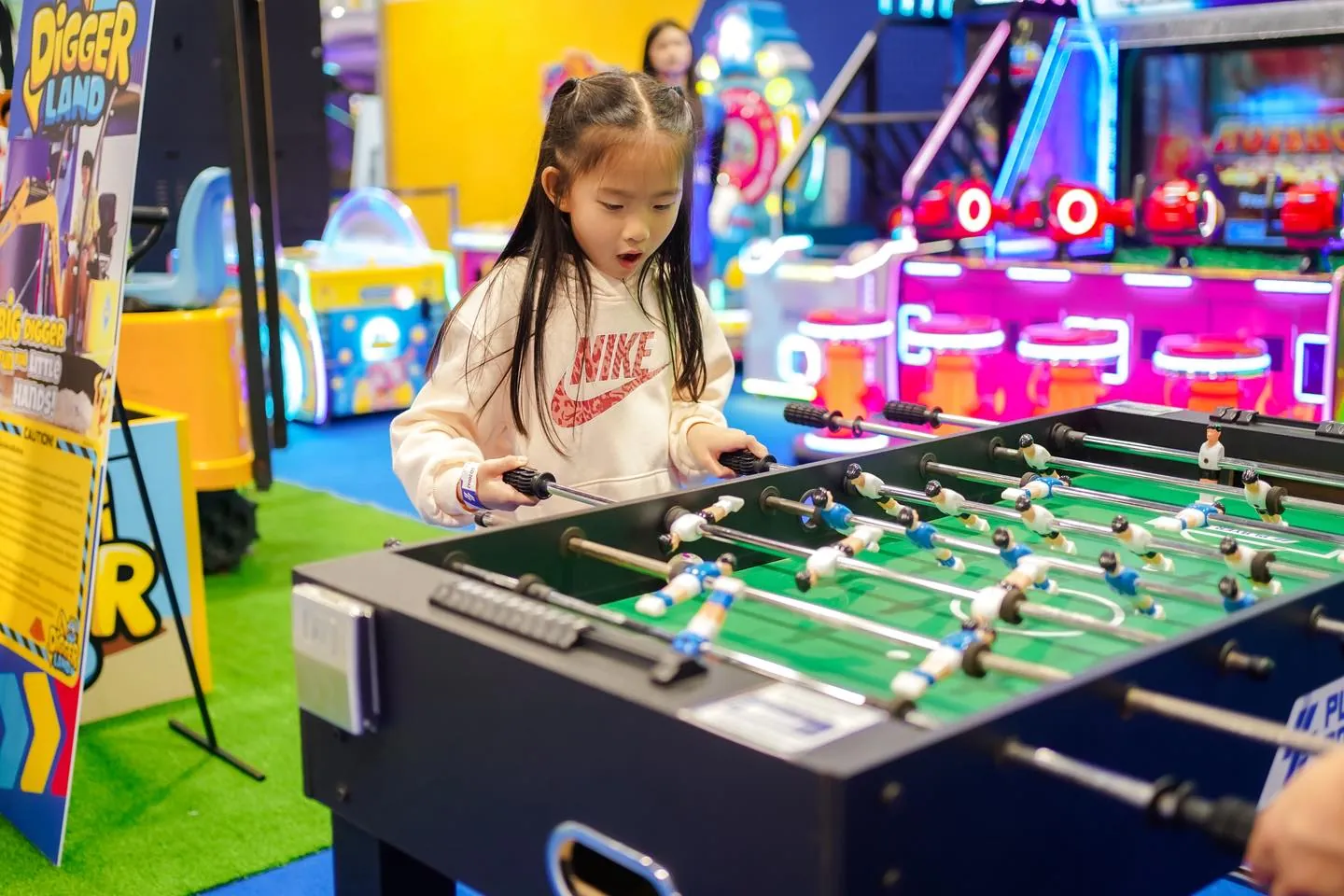Girl playing foosball table at Central Rama 3 Playerbox