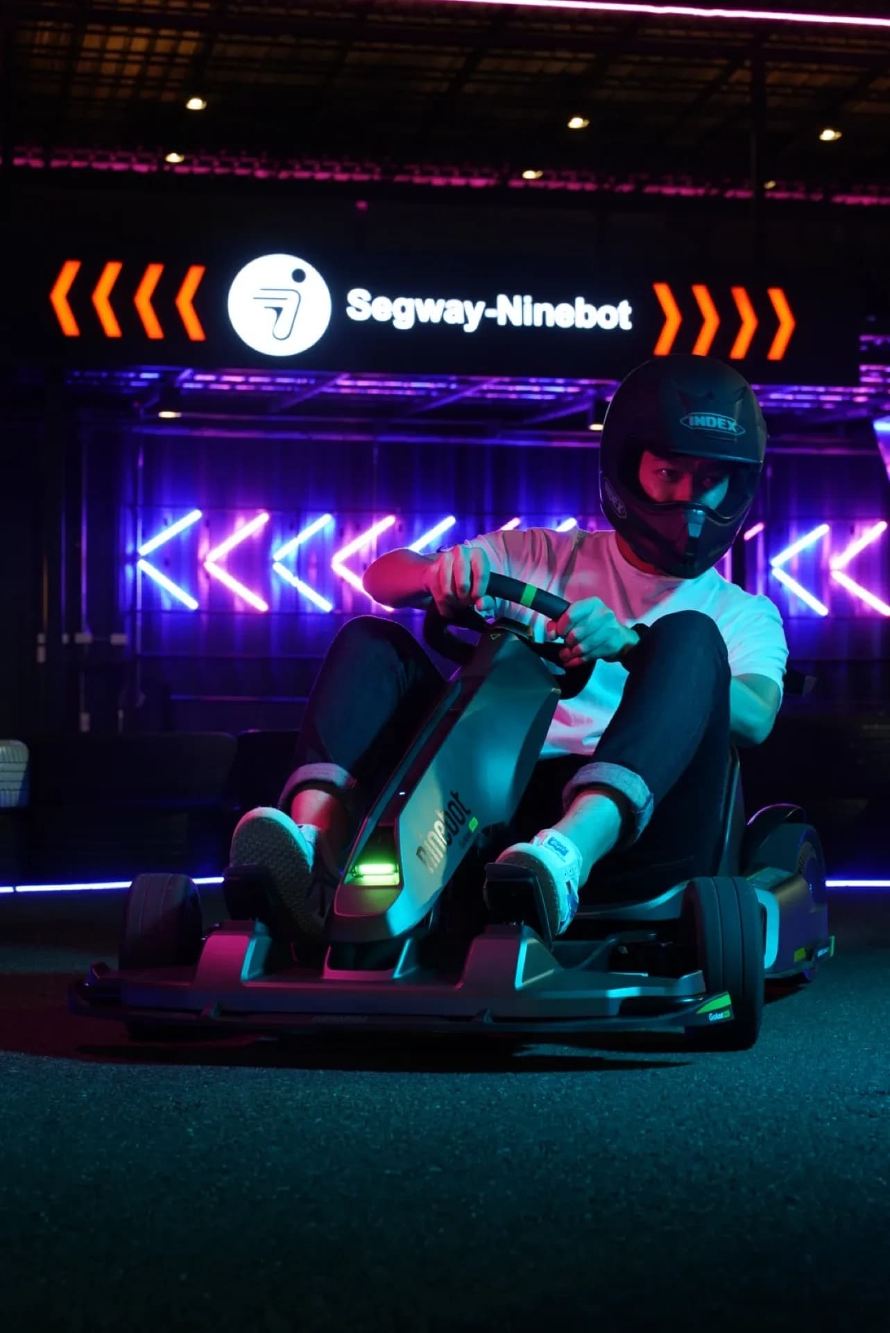 Driver in a Segway kart under the partner signage