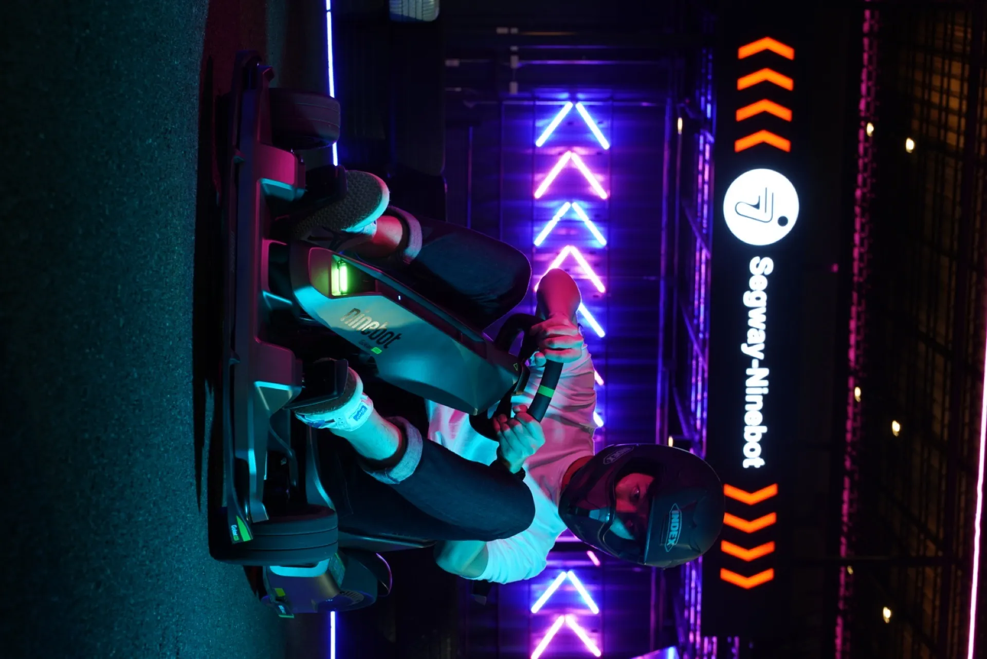 Driver in a Segway kart under the partner signage