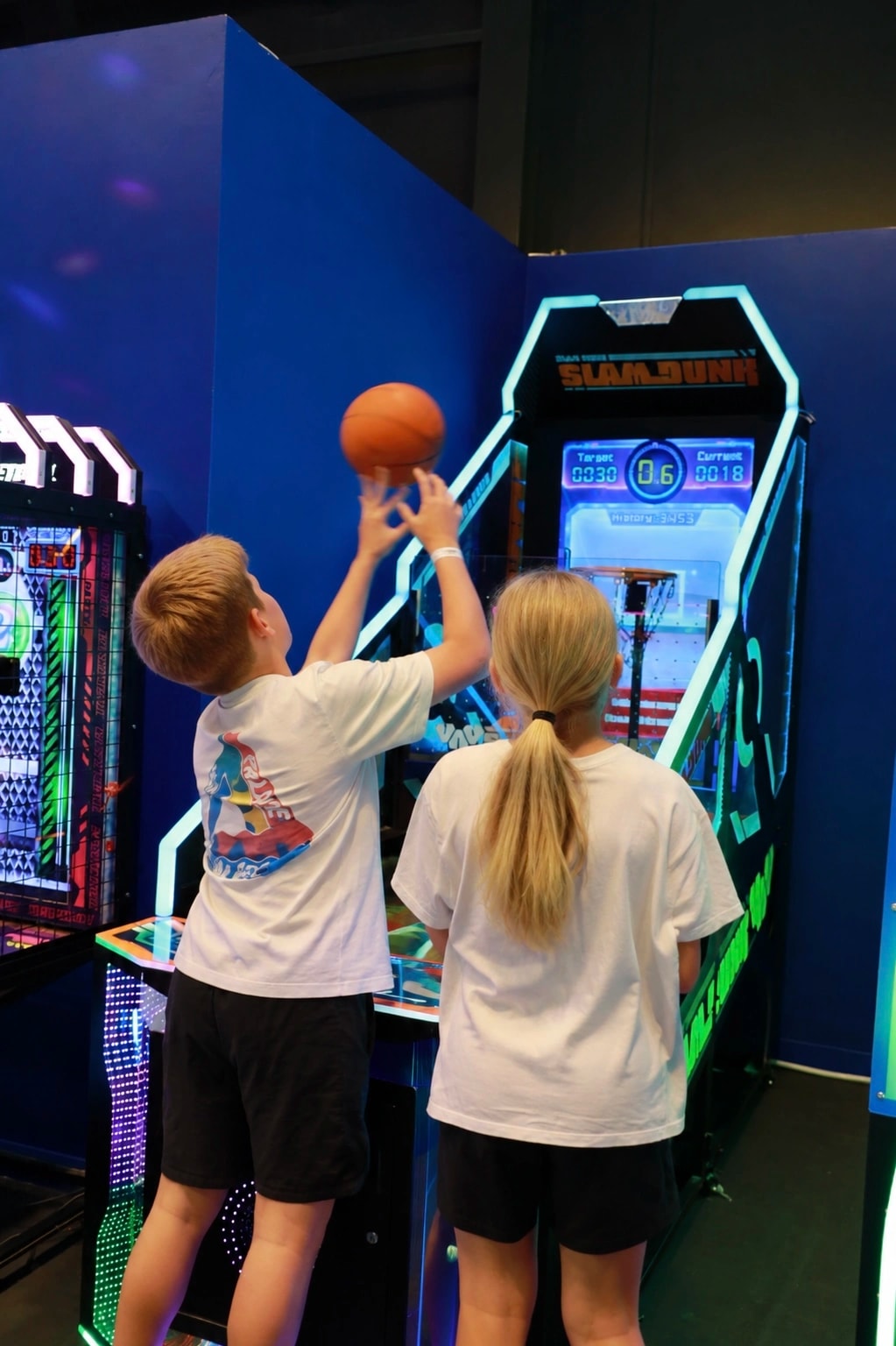 Two kids shooting hoops at the Slam Dunk basketball arcade at Playerbox ICONSIAM