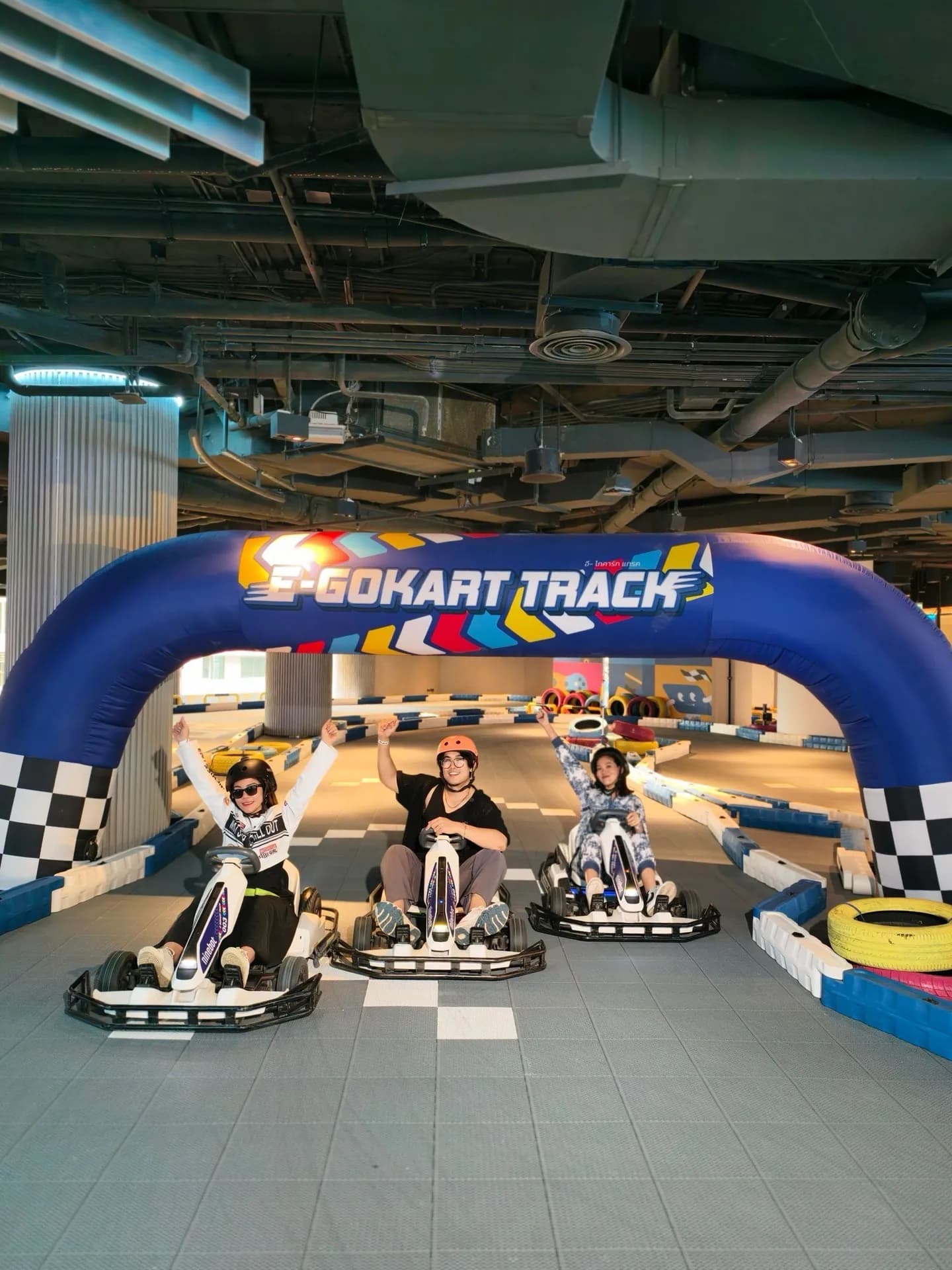 Kid driving a Segway kart on the blue indoor mat track