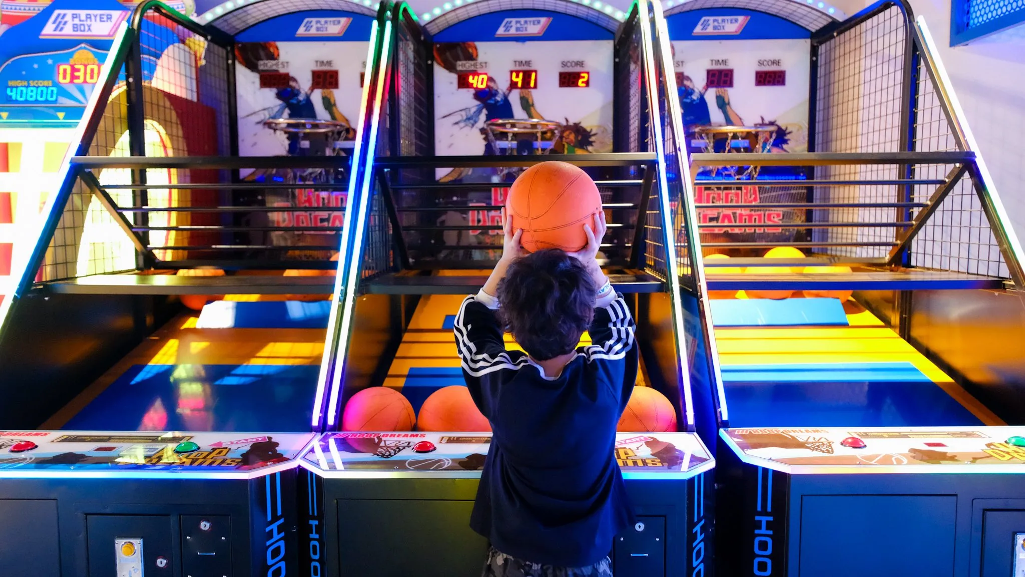 Child shooting hoops at the neon basketball arcade at Siam Discovery Playerbox