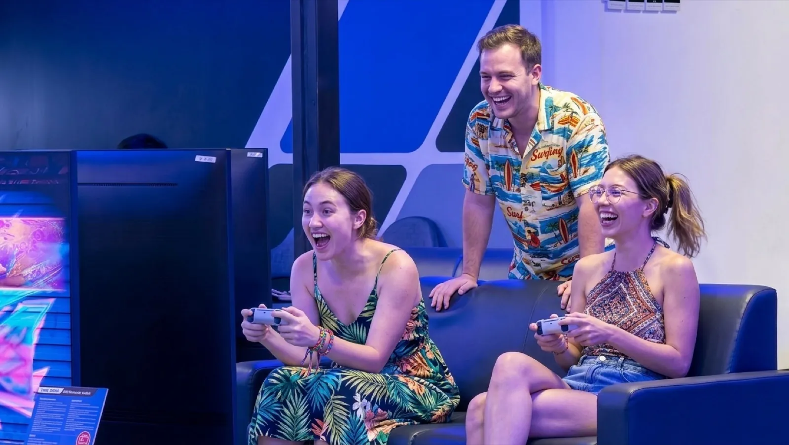 Friends laughing on the couch playing console games at Chula 28