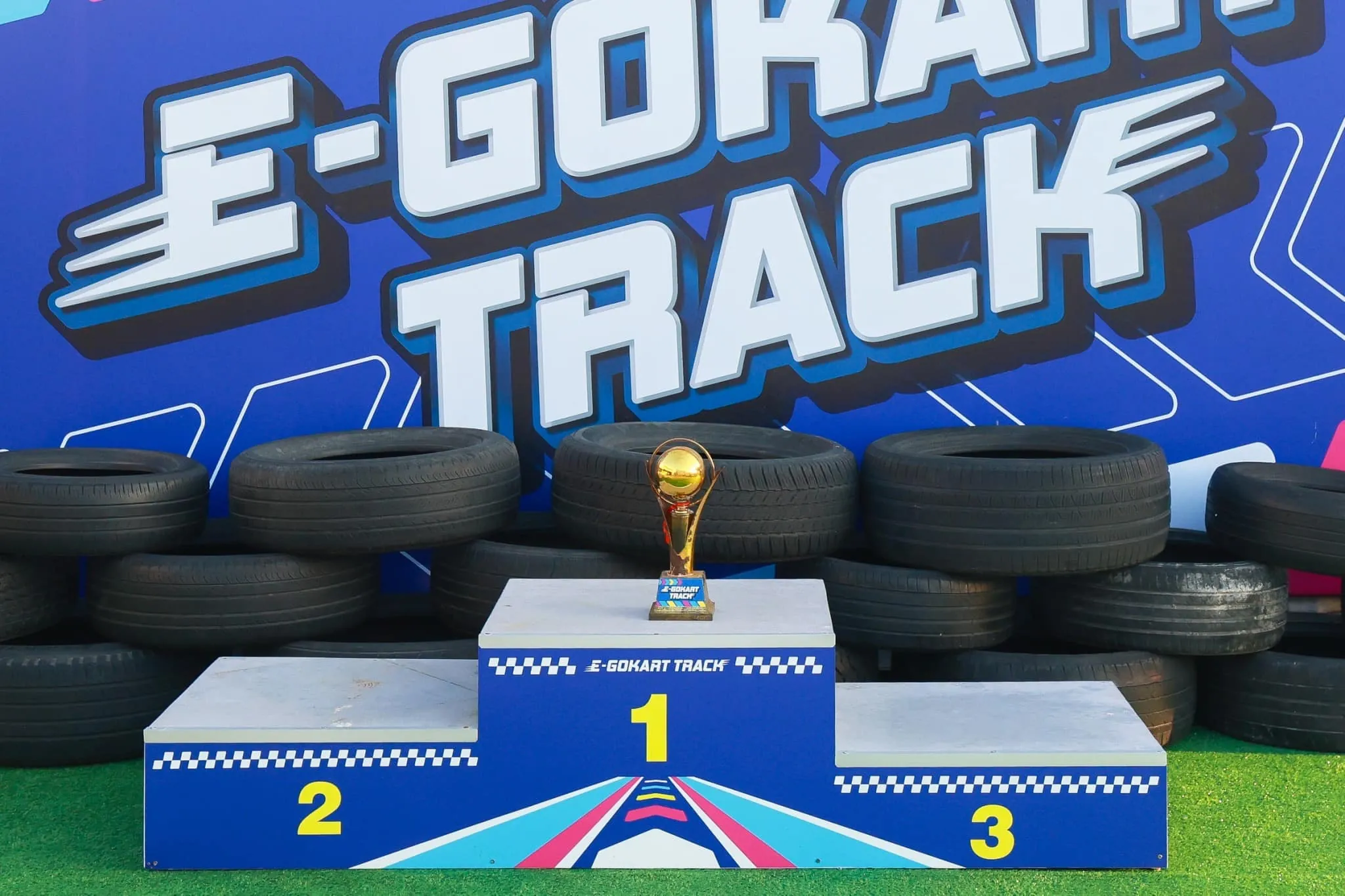 Kids on the winners podium with a trophy at the Phuket E-Gokart track