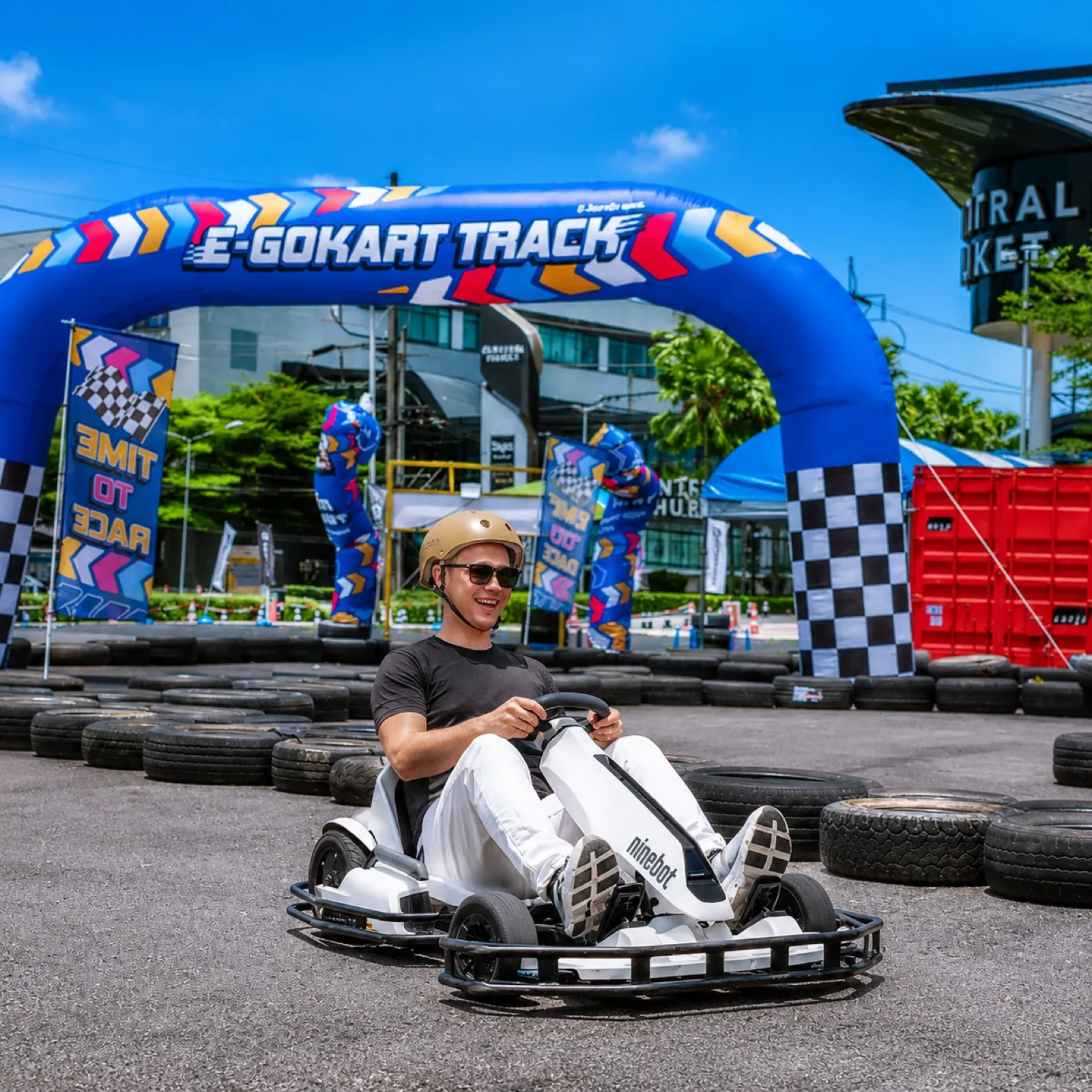 A driver giving a thumbs-up in front of the Central Phuket building at the outdoor kart track