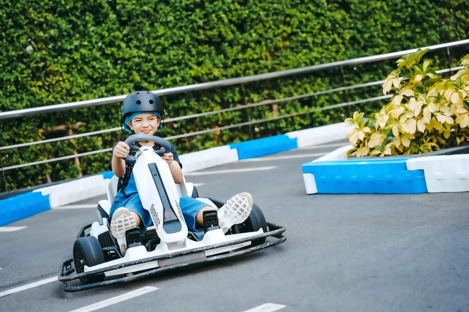 A staff member helping a young driver get set in the kart at Terminal 21 Pattaya