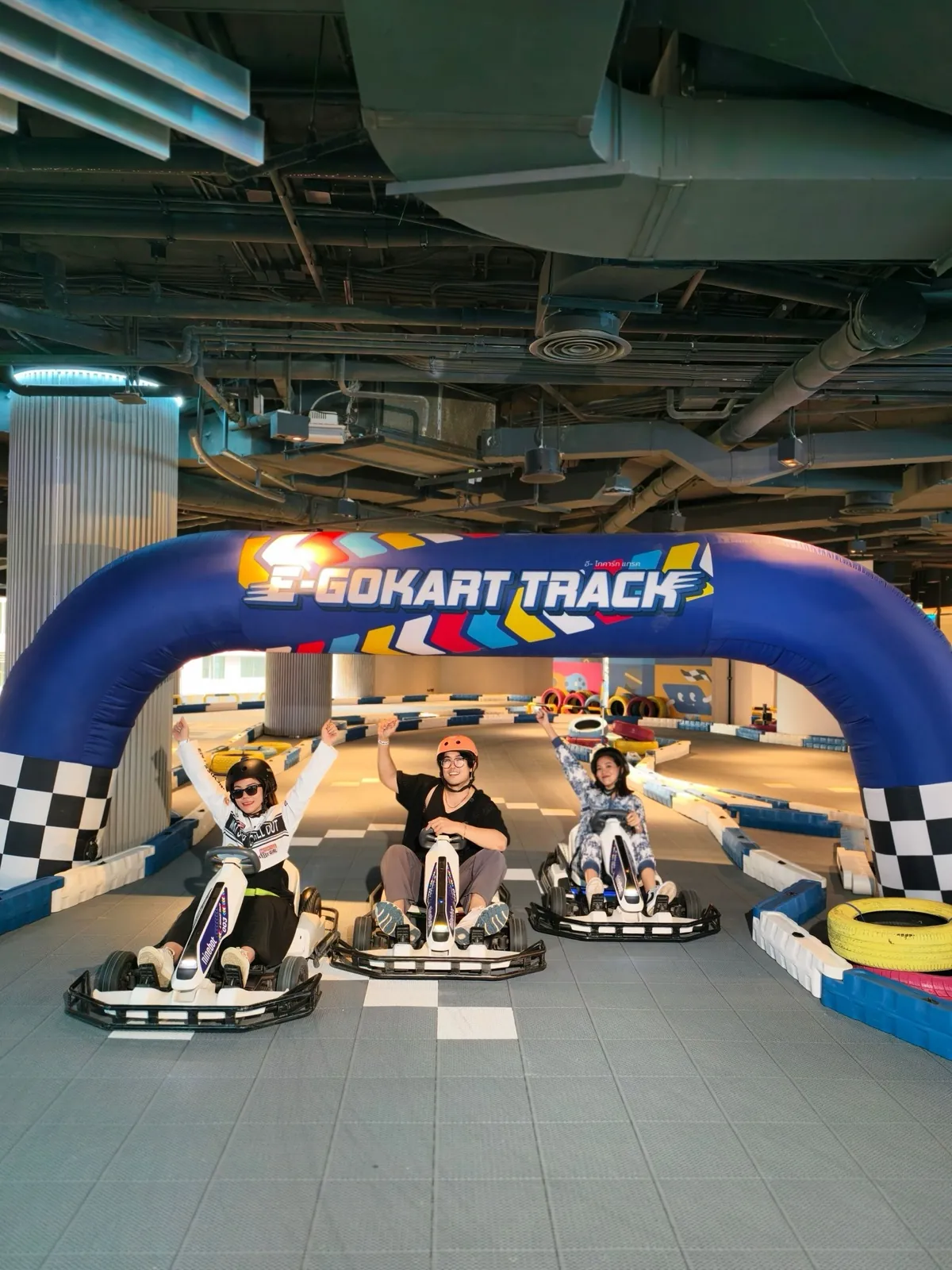 Friends celebrating under the E-Gokart Track arch at Siam Discovery