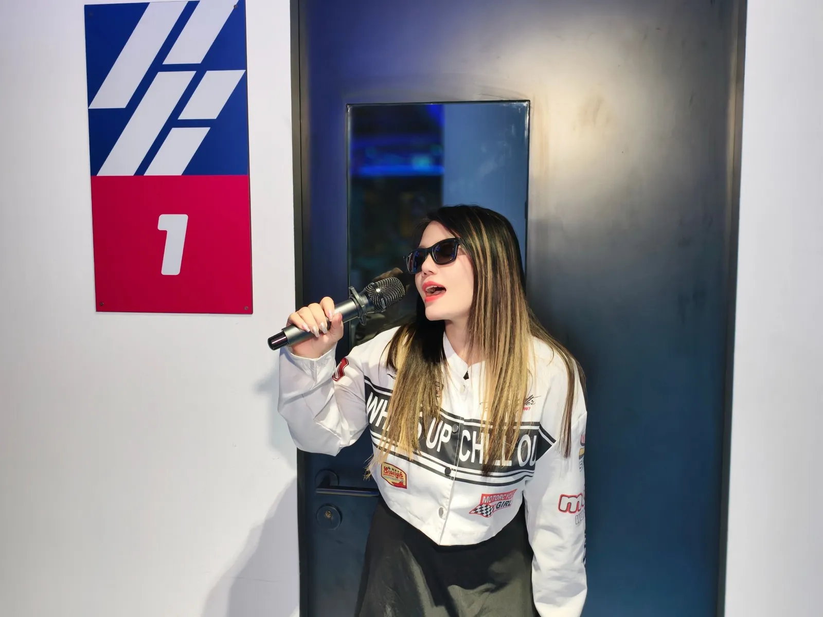 A singer with sunglasses holding the mic at the Siam Discovery karaoke
