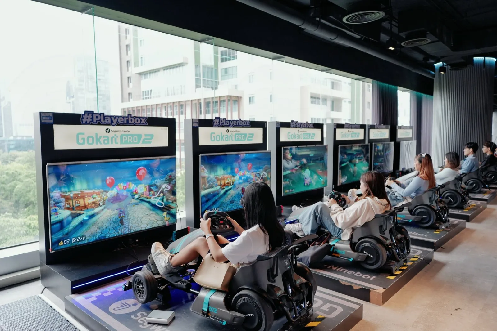 A row of racing simulators with city views at Siam Discovery